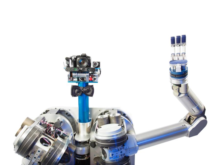 Closeup shows the robot waving it's articulated three fingered hand. 