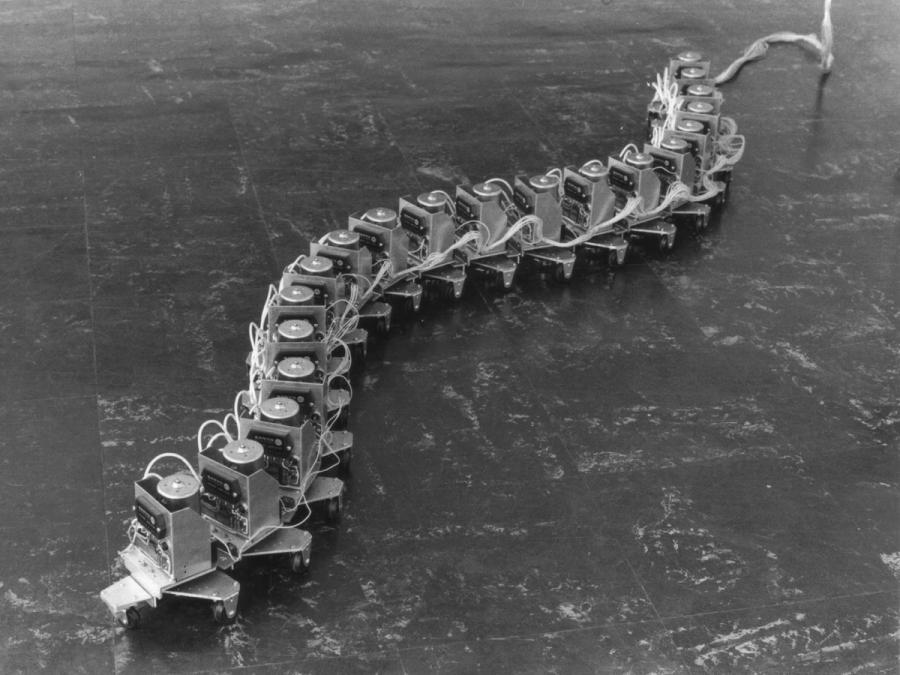 A black and white photo of a segmented wheeled robot.