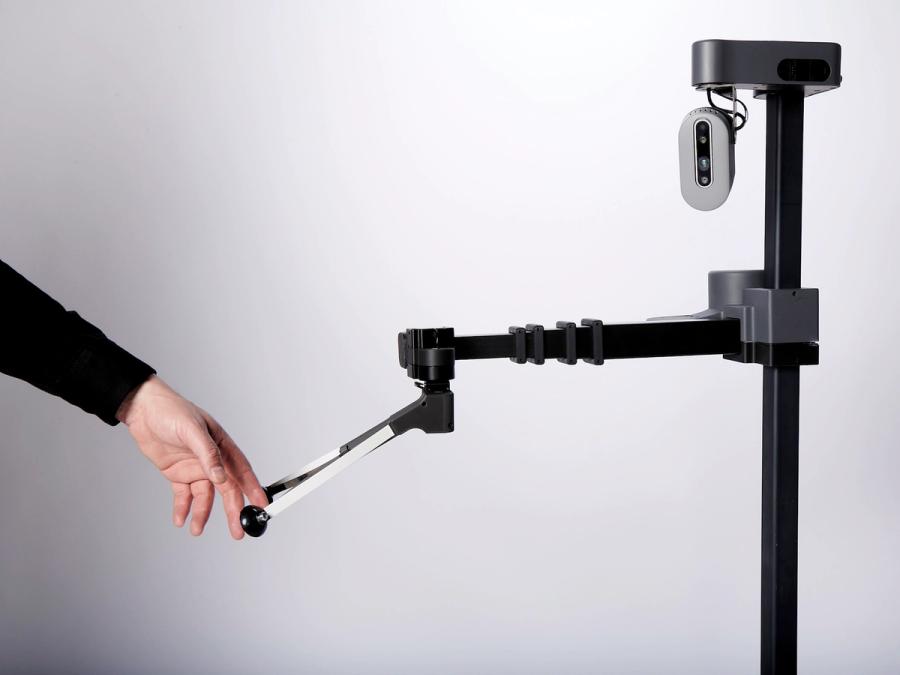 A hand holds the end of the robots gripper.