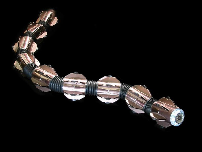 A bronze snake like robot on a black background.