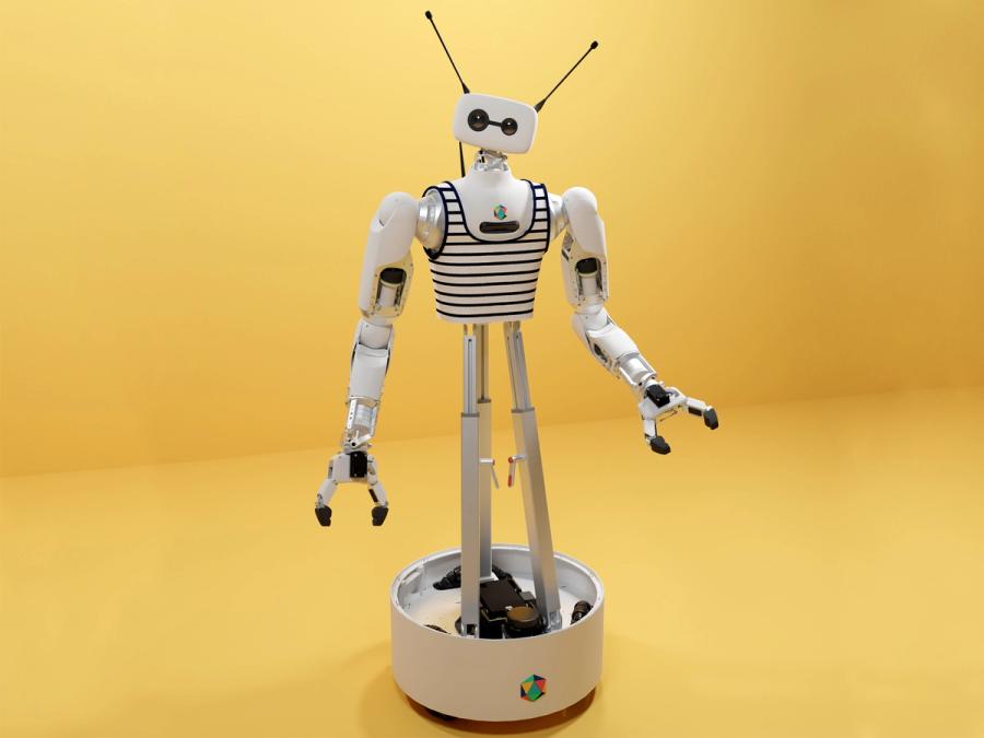 Reachy 2, a robotic torso with two white arms ending in two finger gripper hands, and a white head with two camera eyes, one large and one small, sits in front of a yellow background. There are two pointed antenna protruding from the robot's head, and it wears a black and white striped tank top.