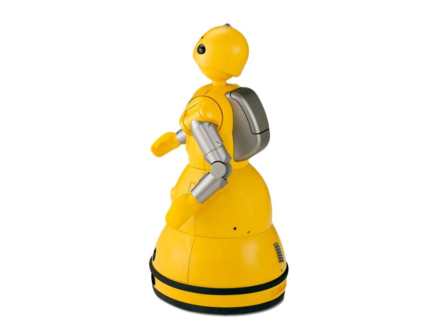 Rear view of a yellow robot with a round flat base and simple arms, head and a grey backpack structure.